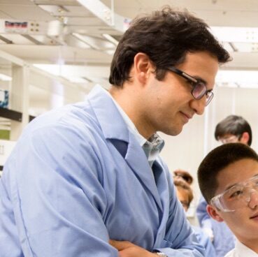 Professor speaking with a student in a laboratory.