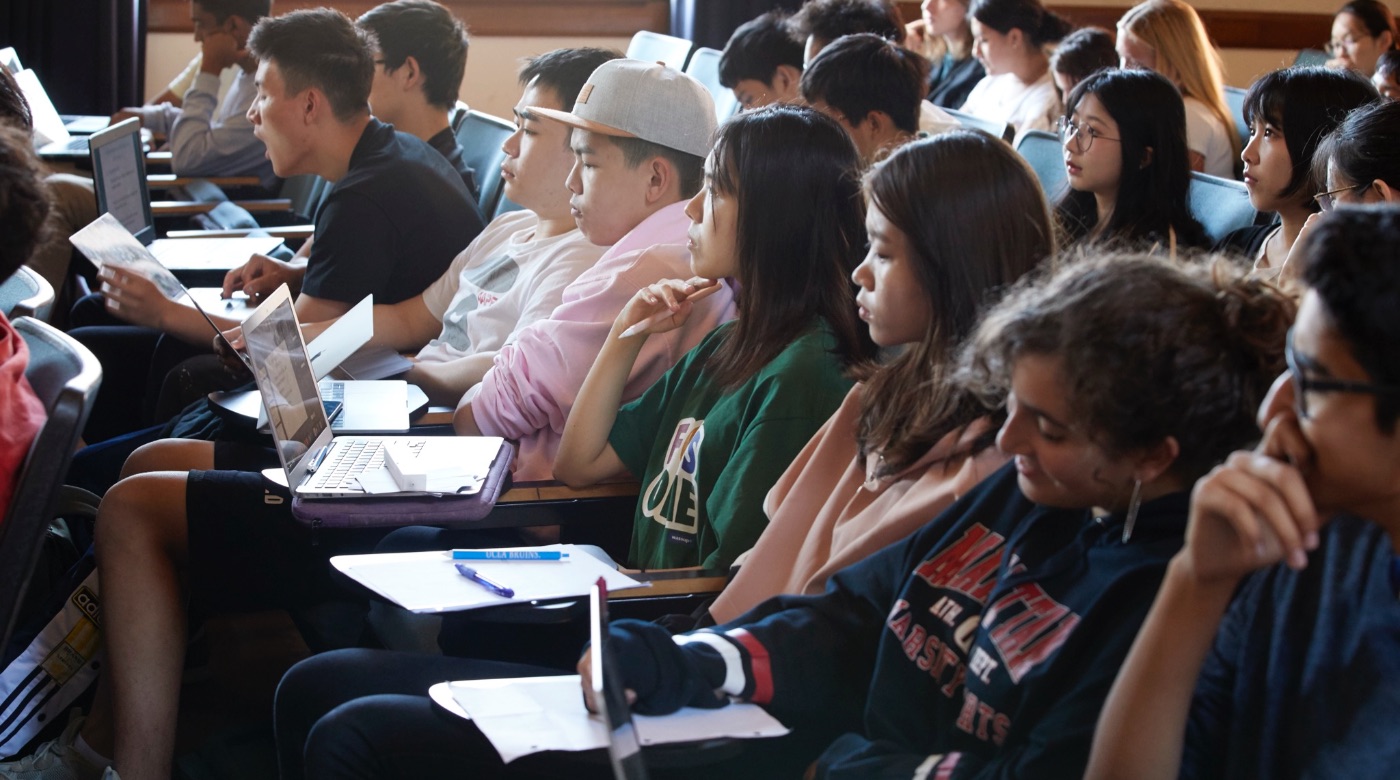 Students listening to a lecture and taking notes.