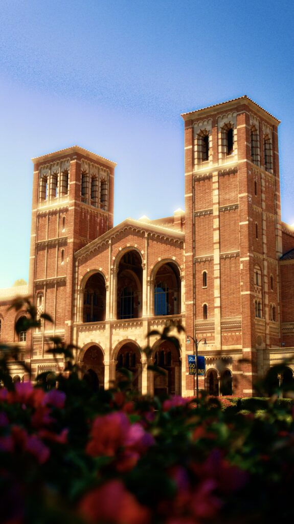 Royce Hall pictured against a clear blue sky, surrounded by vibrant flowers.